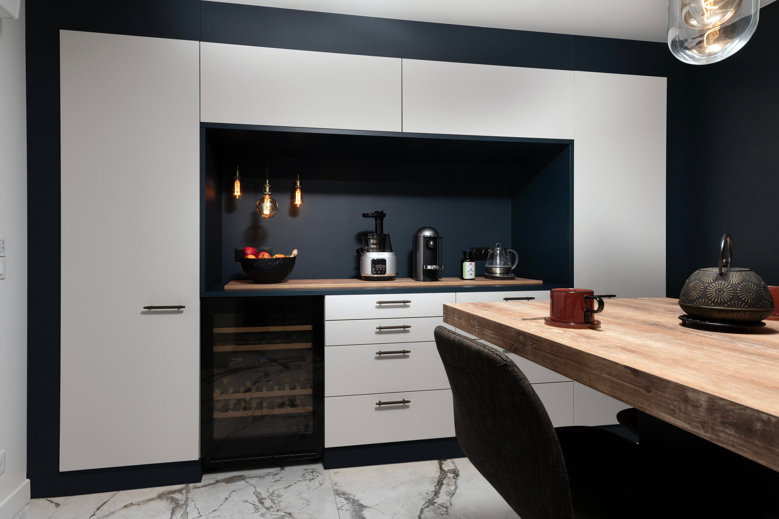 Cuisine blanche avec mur d'accent noir et sol en marbre