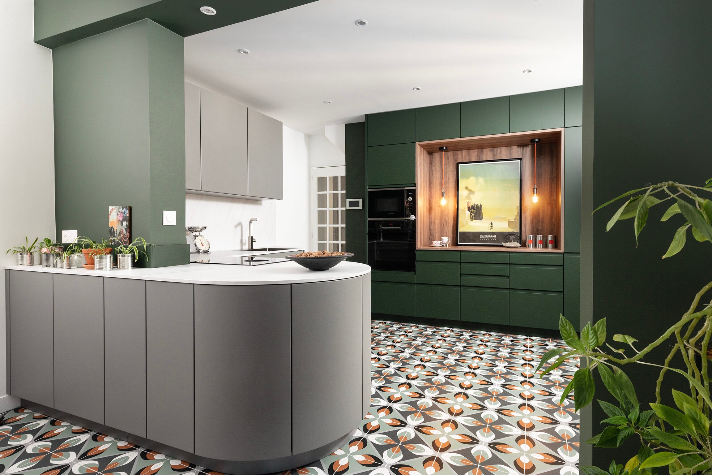 Cuisine aux armoires vert émeraude et grises sur carrelage à motifs géométriques — réalisation Dec Home