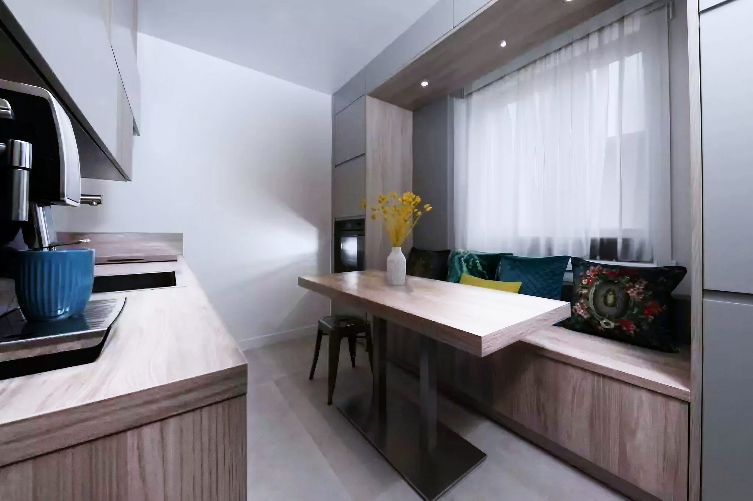 Cuisine avec armoires et comptoirs en bois clair et banc encastré