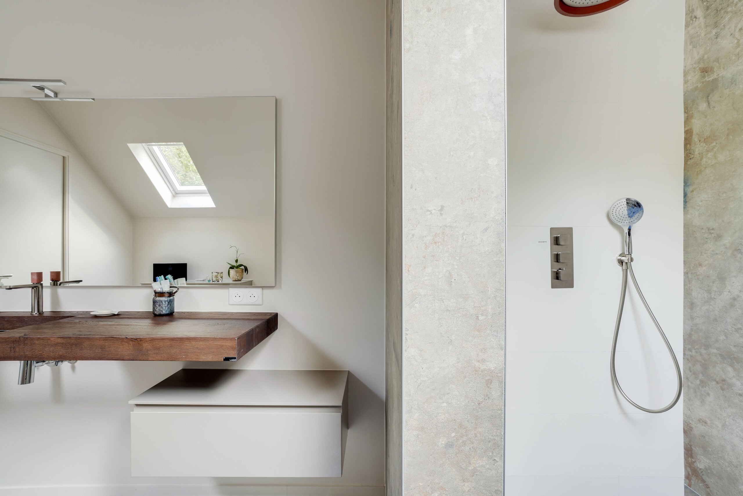 Vue d'ensemble de la salle de bains sous combles avec plan vasque en bois et accès à la douche italienne — réalisation Dec Home